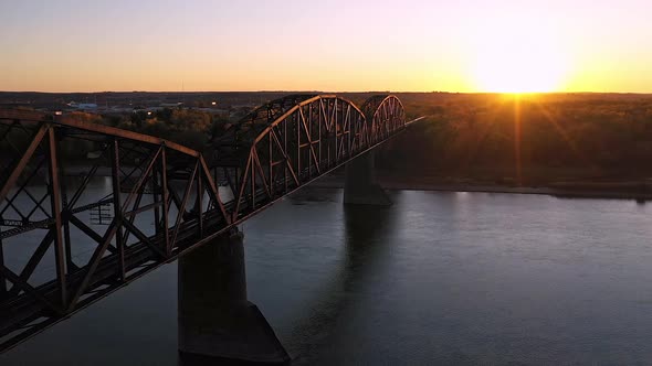 Flying along historic old railroad bridge in North Dakota at sunset alt