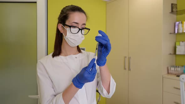 Doctor Filling Syringe with Medicine Before Making Botox Injection in Beauty Clinic alt