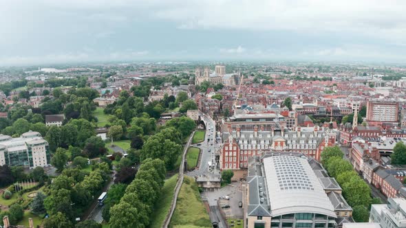 Low establishing drone shot towards York Minster Cathedral over city wall cloudy day alt
