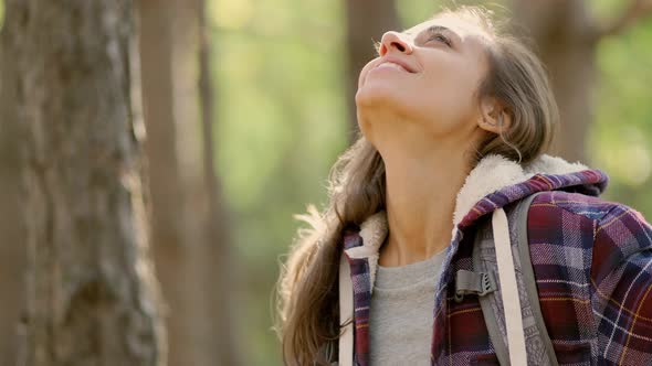 Tourist Hiker Woman with Backpack Open Arms in Woods, Enjoying Fall Autumn Season. alt