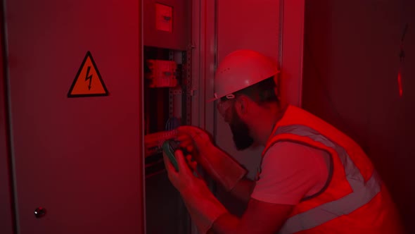 Electrician Working in Red Alarm Light alt