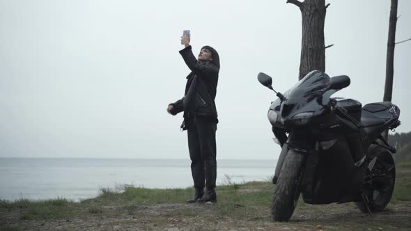 Wide Shot of Embarrassed Caucasian Young Woman Raising Smartphone Searching Mobile Network. Black alt