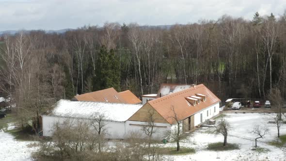 Farmhouse secluded in tree grove in early winter countryside, drone. alt