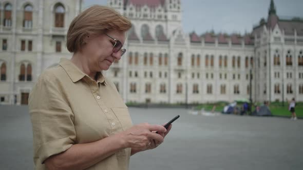 Mature Woman with Cell at Kossuth Square in Budapest Hungary alt