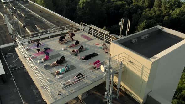 Group of People Do Yoga on the Roof of a Building. Healthy Lifestyle in Urban Environments alt