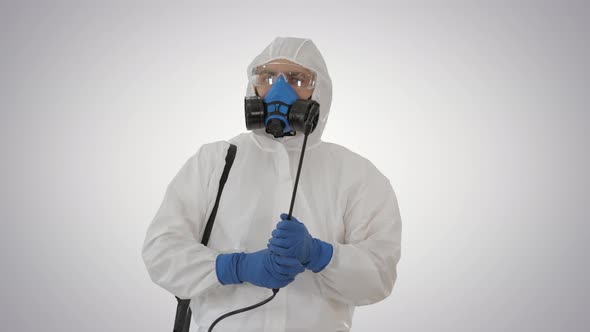 Man Wearing an Personal Protective Equipment Suit, Gloves, Mask, and Face Shield Ready To Disinfect alt