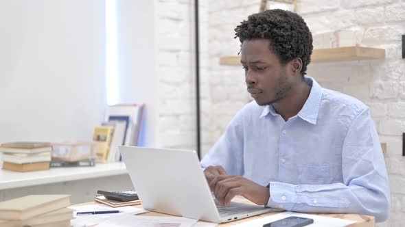 Excited African Man Working on Laptop alt