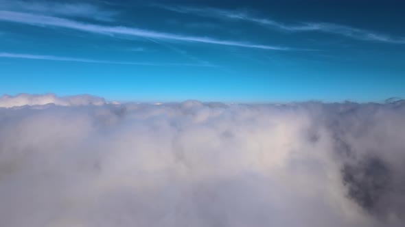 Aerial View From High Altitude of Earth Covered with White Puffy Cumulus Clouds on Sunny Day alt