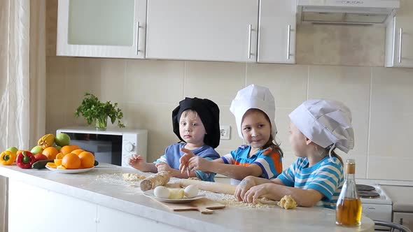 Children Cook in the Kitchen with Mom. Three Small Children Made a Mess on the Kitchen Table