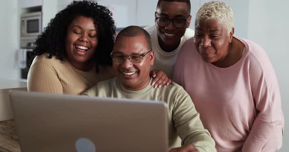 Happy latin family having fun on a video call using computer laptop at home - Technology concept alt