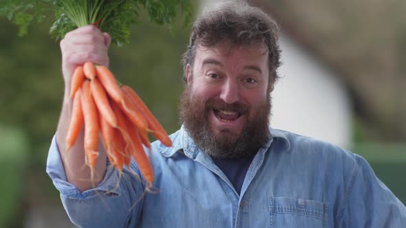 Happy farmer or seller with bunch of fresh carrots