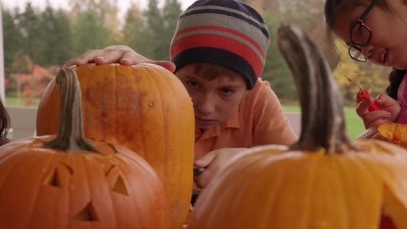 Young boy carving pumpkin for Halloween