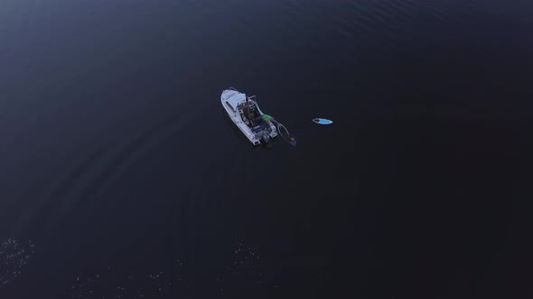 Boat Picks Up Surfer on Hydrofoil From Water Evening Light Bird's Eye View