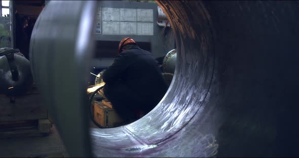 A Professional Worker in a Protective Mask Works with a Grinder in a Factory alt