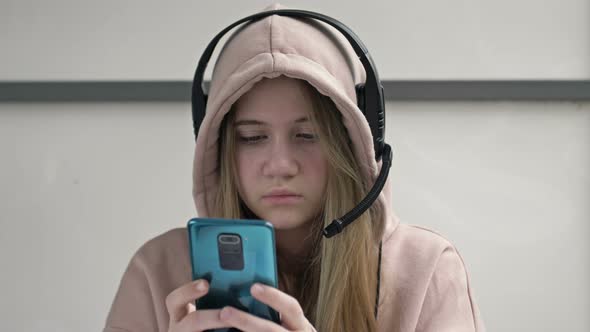 Teen Girl Holding Phone Obsessed with Smartphone Social Media Apps Sitting Alone at Home alt