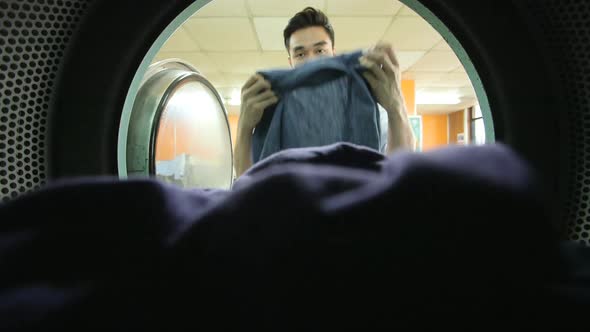 A Young Man collects his laundry from the washing machine