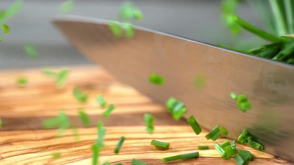 Super Slow Motion Shot of Cutting Chive on Wooden Cutting Board at 1000Fps. alt