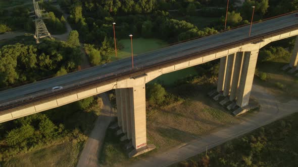 Aerial high angle shot flying over traffic driving on Zarate Brazo Largo bridge at golden hour alt