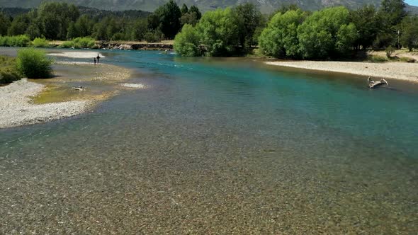 People fly fishing in Cholila River and Lake, Patagonia, Argentina, aerial forward flyover wide shot alt
