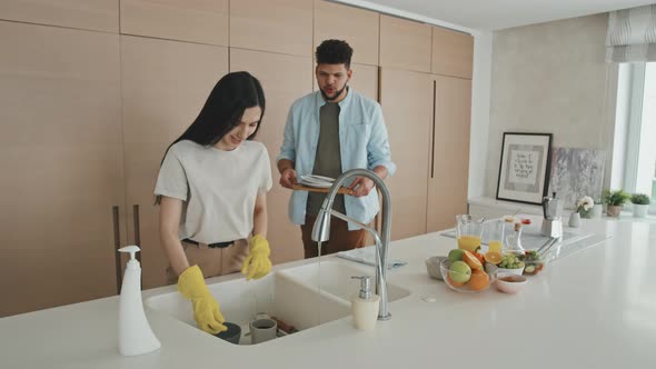 Man Helping Wife To Wash Dishes After Breakfast alt