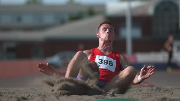 Track athlete landing in sand on long jump in super slow motion, shot on Phantom Flex 4K