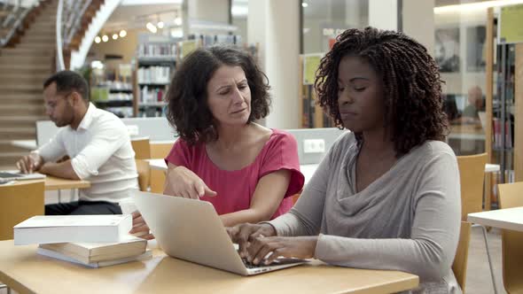 Pensive Students Working Over Project at Library alt