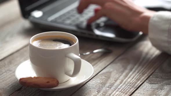 Works At The Computer Hands Are Typing, Coffee Is In The Foreground. The Girl's Hands Are Typing alt