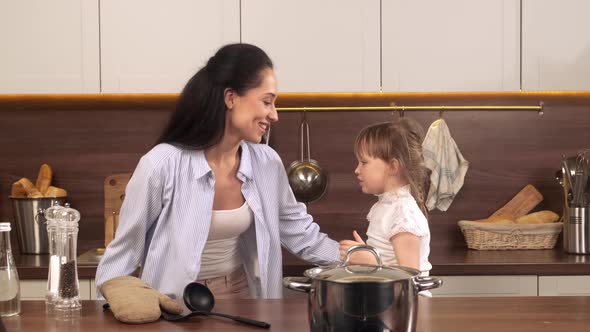 Mom and Little Daughter Dancing in the Kitchen alt