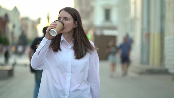 Cryptocurrency Analyst Walking Down the Street to the Office and Drinking Hot Lotte Coffee