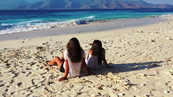 Women best friends on luxury bay beach lifestyle by blue ocean with white sandy background of Gili A alt
