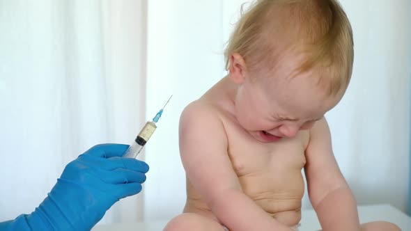 Doctor Vaccinating Crying Baby in Clinic alt