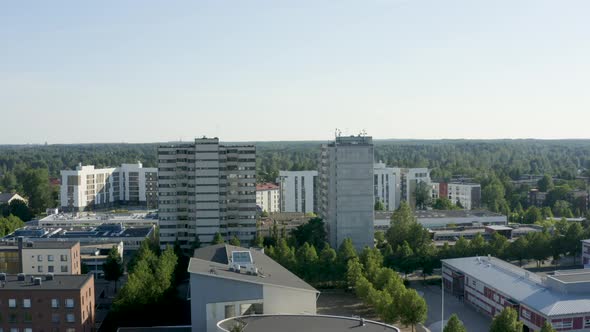 Reversing aerial shot of two large towers and a round building below, Finland. alt