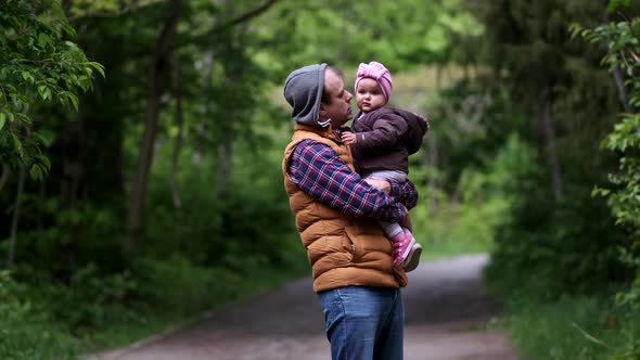 Dad with a daughter in her arms in the park are playing. alt