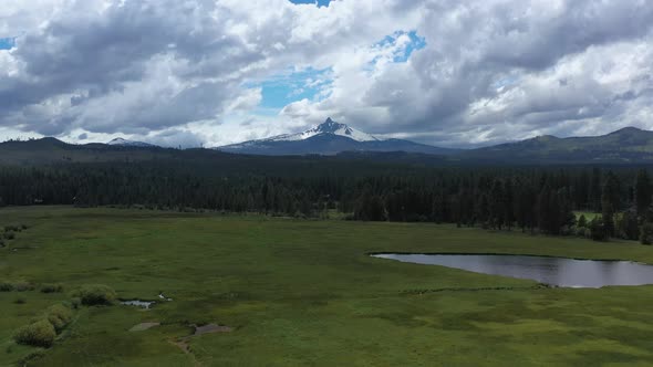 Aerial flying toward Mt. Washington in the Cascade Mountain Range in Oregon during summer. alt