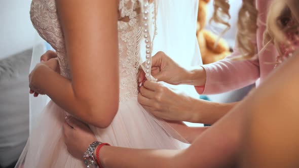 Bride's Girlfriend Helps Bride Dress Up Her Wedding Dress alt