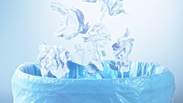 Super Slow Motion Shot of Crumpled Papers Falling Into Trash Can at 1000Fps alt