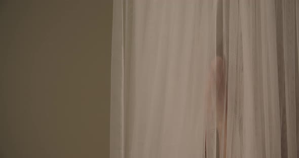 Young Woman Moving From Behind Curtain