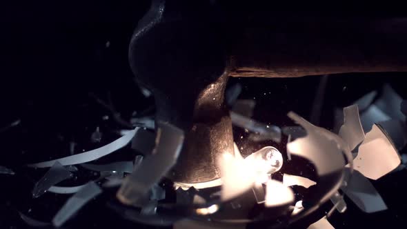 Slow motion of light bulb shattering from hammer hitting it. alt