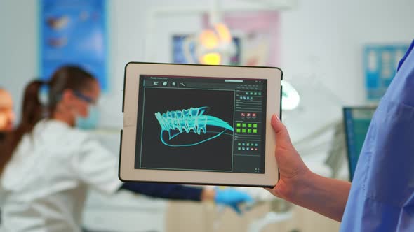 Close Up Dentist Assistant Holding Tablet with Digital Dental Fingerprint alt