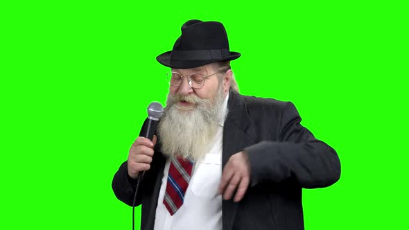 Elderly Entertainer Talking Into Microphone alt