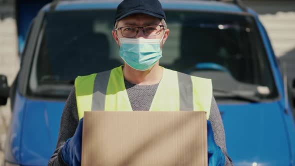 Masked Courier Holding a Parcel in His Hands alt