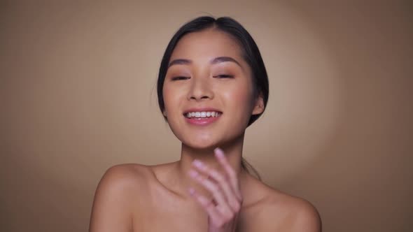 Beautiful Young Asian Woman Touching Soft Cheek Smile with Clean and Fresh Skin