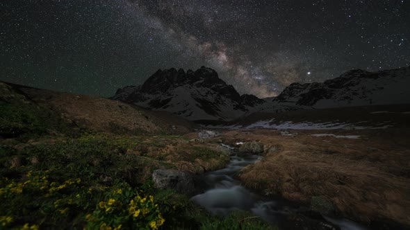 Timelapse of Milky Way Above the Snow-capped Mountains and Creek