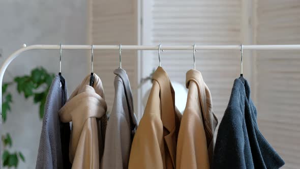 Woman Choosing Coat Clothes During Shopping or Being in Wardroom at Home alt