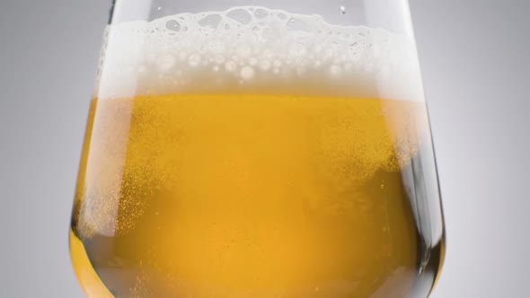 Slow motion, Close up shot Fresh Beer pouring into glass, white background alt