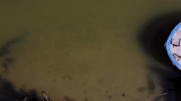 An old, abandoned boat along the shore of the Segura River - straight down bird's eye view alt
