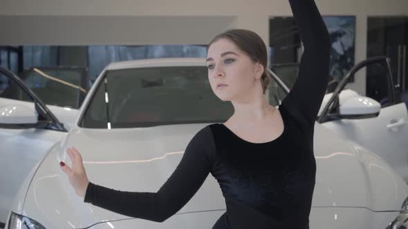 Slowmo of Beautiful Caucasian Female Ballet Dancer Moving in Front of White Automobile. Young Woman alt