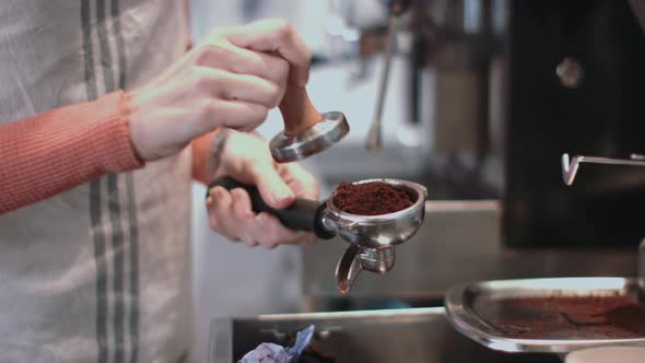 Female barista in cafe making coffee