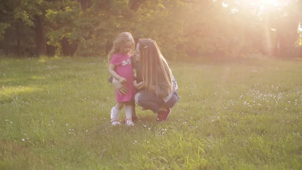 Little Kid with Long Hair Sitting on Front of Her Mother