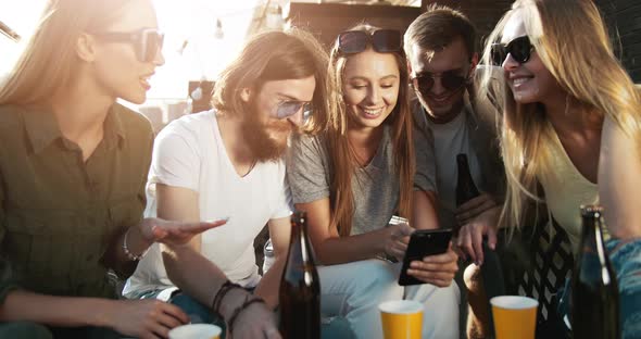 Young Group of Friends Browsing Smartphone on Roof